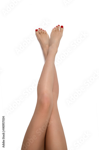 beautifully groomed woman feet and legs on an isolated white background