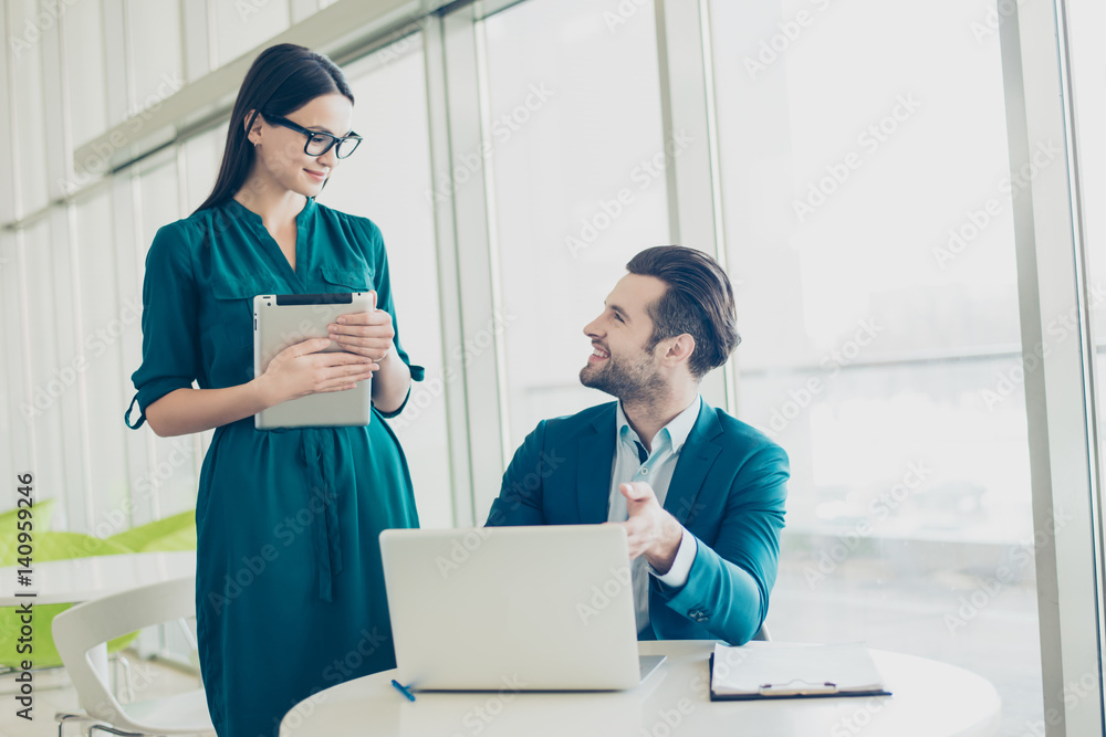 Photo of smiling happy businessman pointing on the screen and secretary listening to the boss