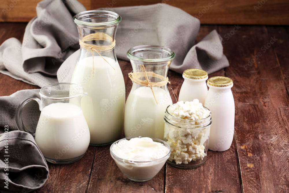 milk products - tasty healthy dairy products on a table on: sour cream in a white bowl, cottage cheese bowl, cream in a a bank and milk jar, glass bottle and in a glass milk products - tasty healthy dairy products on a table on: sour cream in a white bowl, cottage cheese bowl, cream in a a bank and milk jar, glass bottle and in a glass
