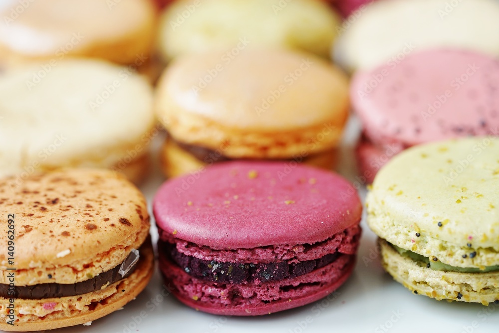 Colorful round macaron cookies on a white platter Colorful round macaron cookies on a white platter