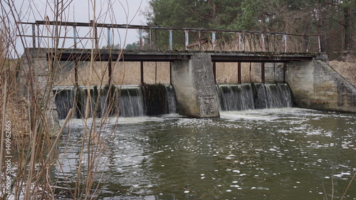 Old dam on the river in the woods.