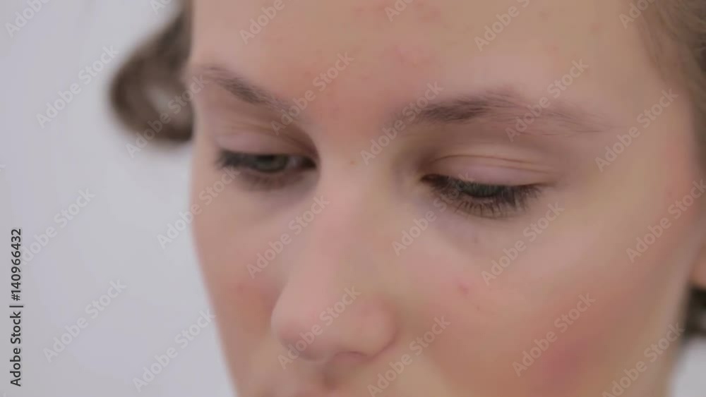 Professional make-up artist combing eyebrows of client in white room. Beauty, visage and fashion concept Professional make-up artist combing eyebrows of client in white room. Beauty, visage and fashion concept