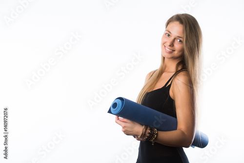 exercise fitness woman ready for workout standing holding yoga mat isolated on white background. Sporty fit beautiful blonde girl. Caucasian female fitness model.
