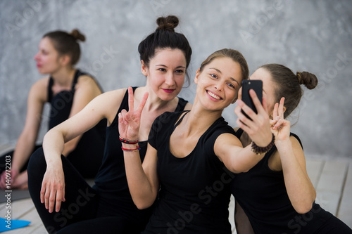 Yoga class of cheerful millennial friends people takes a selfie photo