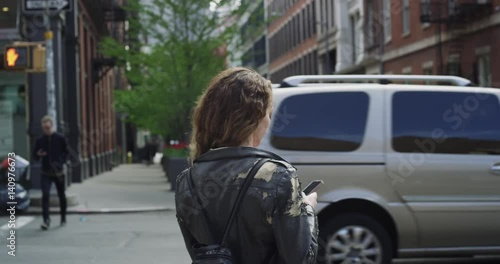 Young woman waits at crosswalk medium shot