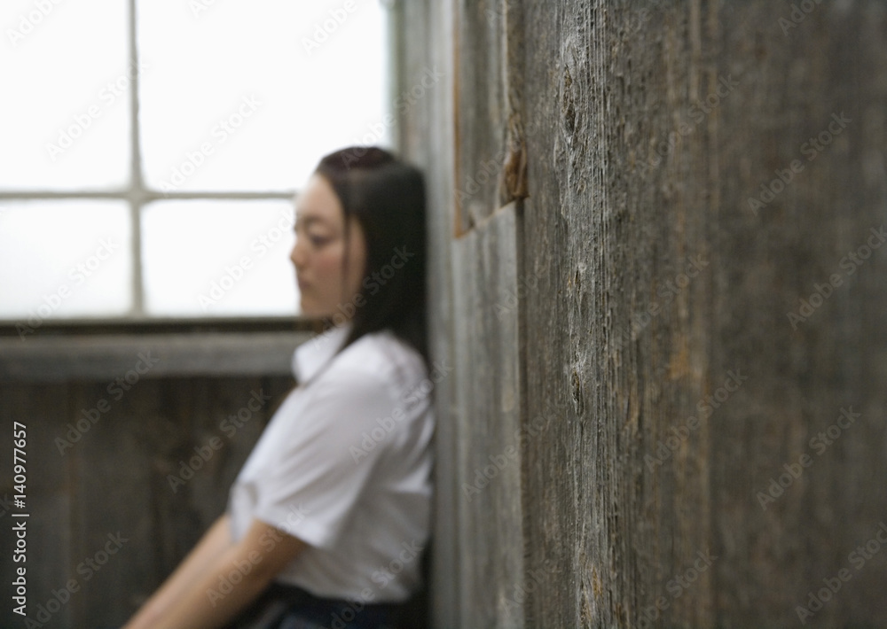 Teenage girl leaning against wall