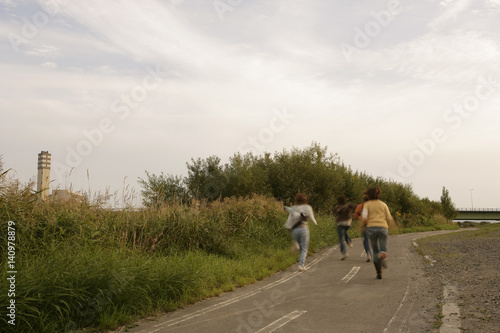 People runing road along field
