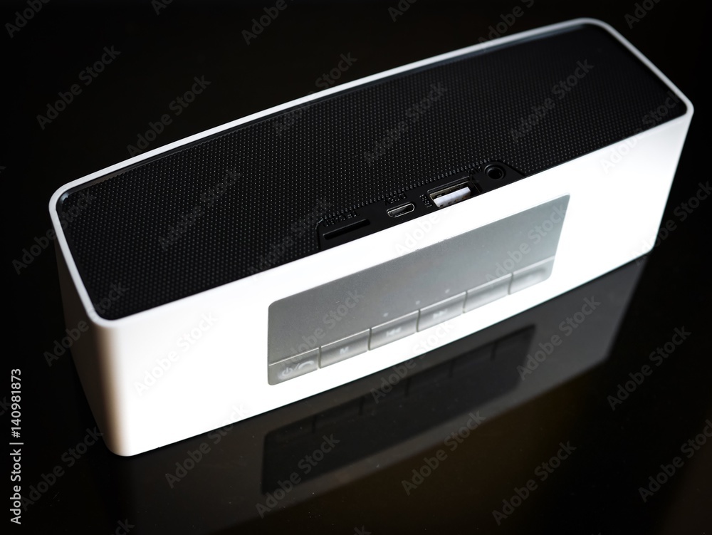 Bluetooth speaker on wooden table Bluetooth speaker on wooden table
