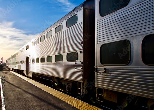Commuter train passing through town, leaving station no one on platform