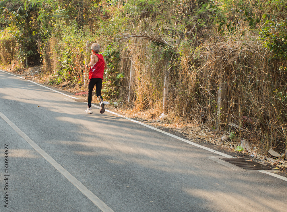 old fitness man running at forest trail old fitness man running at forest trail