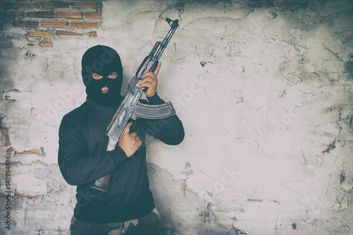Foto terrorist in black uniform and mask with kalashnikov
