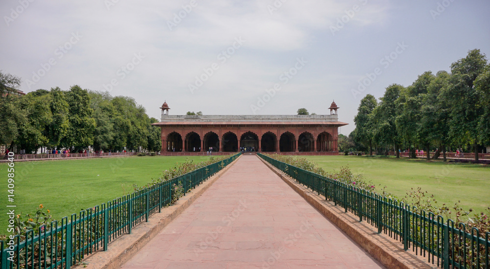 Symmetrical path leading to building with archways in public gardens