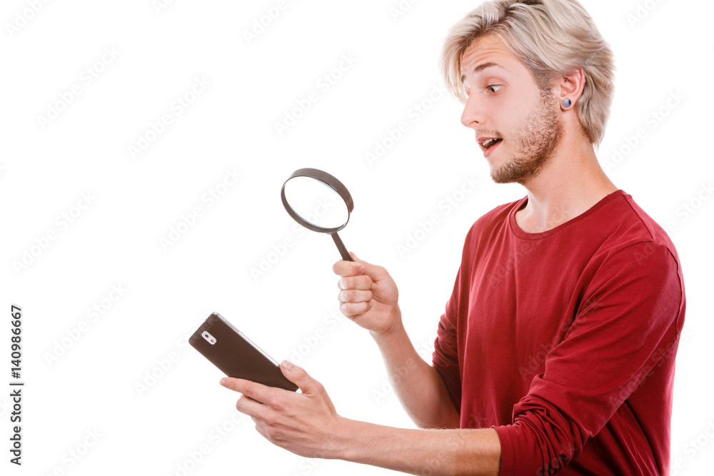 Man reading message on phone using loupe Man reading message on phone using loupe