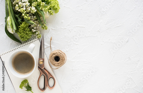 Feminine flatlay with flowers and ccoffee on white tabletop photo