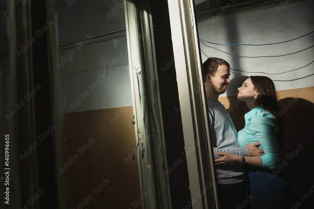 young man and woman standing in a dark corridor young man and woman standing in a dark corridor