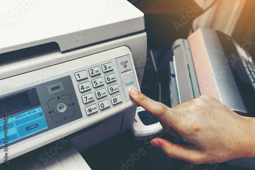 Finger pressing start button of fax machine , office equipment