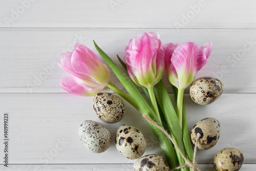 Spring greeting background with Easter eggs and pink tulips.