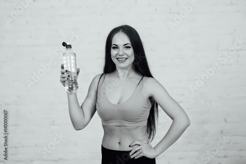 Beautiful girl with braces drinks fresh water photo