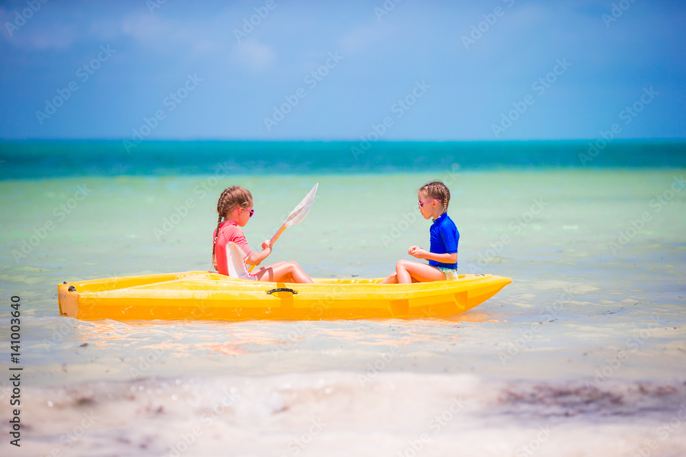 Little girls kayaking in turquoise water in the sea alone