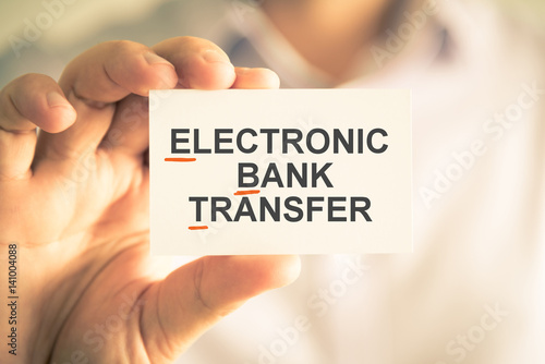 Businessman holding card with EBT ELECTRONIC BANK TRANSFER acronym text
