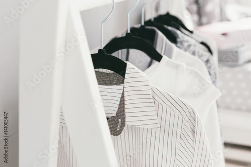 Foto Light wardrobe wear. Shirt shirts and dresses on hangers