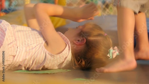 children jump and lie on the trampoline