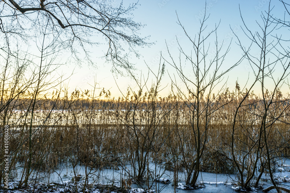 sunset over a snow covered lake in winter