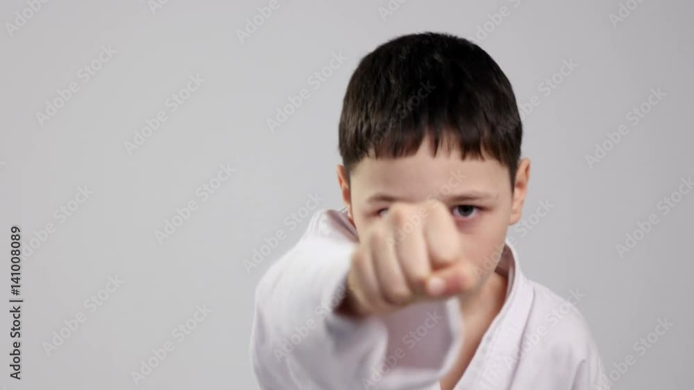 A karateka kid demonstrates two straitforward strikes in studio A karateka kid demonstrates two straitforward strikes in studio