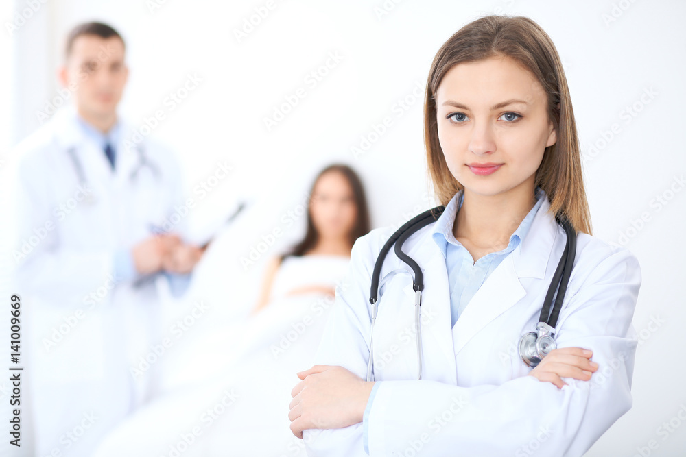 Friendly female doctor on the background with patient in the bed and his physician Friendly female doctor on the background with patient in the bed and his physician
