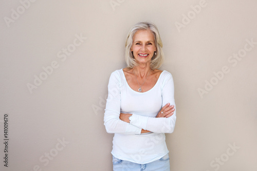 Foto beautiful older woman standing and smiling with arms crossed