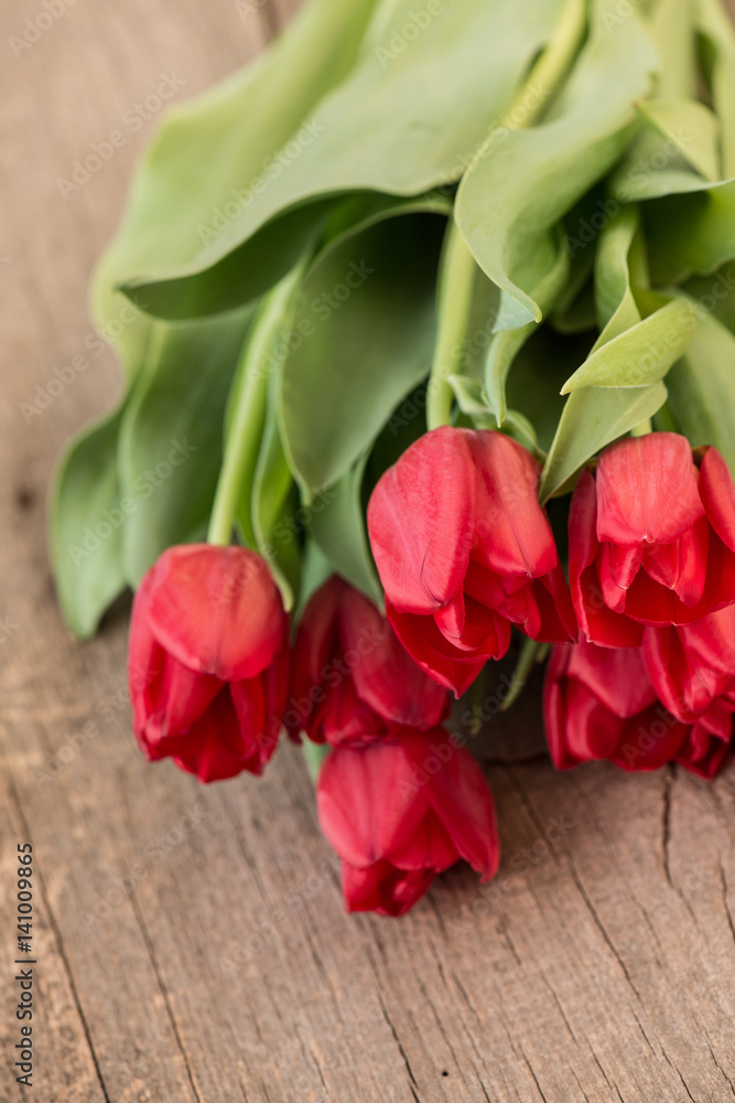 Red tulip flowers on rustic wooden background Red tulip flowers on rustic wooden background
