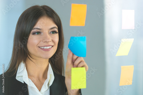 The happy woman glues a sticker on the glass photo