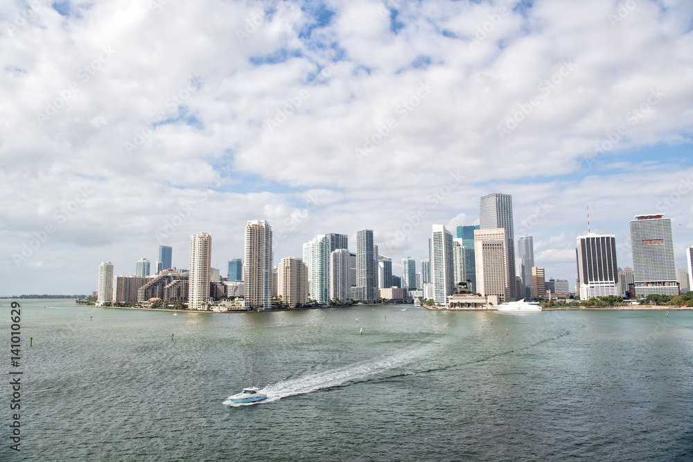 Fototapeta premium Aerial view of Miami skyscrapers with blue cloudy sky, boat sail