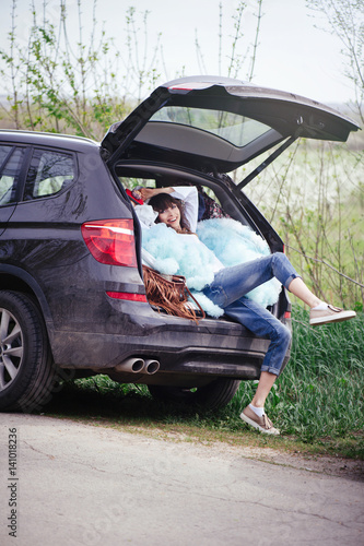 beautiful woman sitting in the car trunk © lanarusfoto