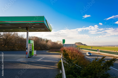 Petrol station on the motorway. Sunset at the gas station. Car traveling on the highway at sunset. Maximal speed. Sunset on the motorway.