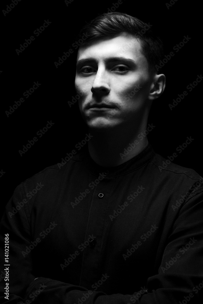 Low key portrait of a man in black shirt in black and white. Low key portrait of a man in black shirt in black and white.