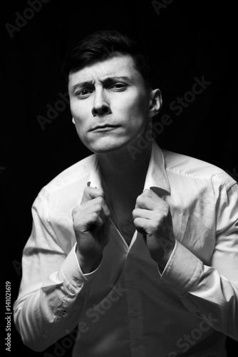 Low key portrait of a man in white shirt in black and white. photo