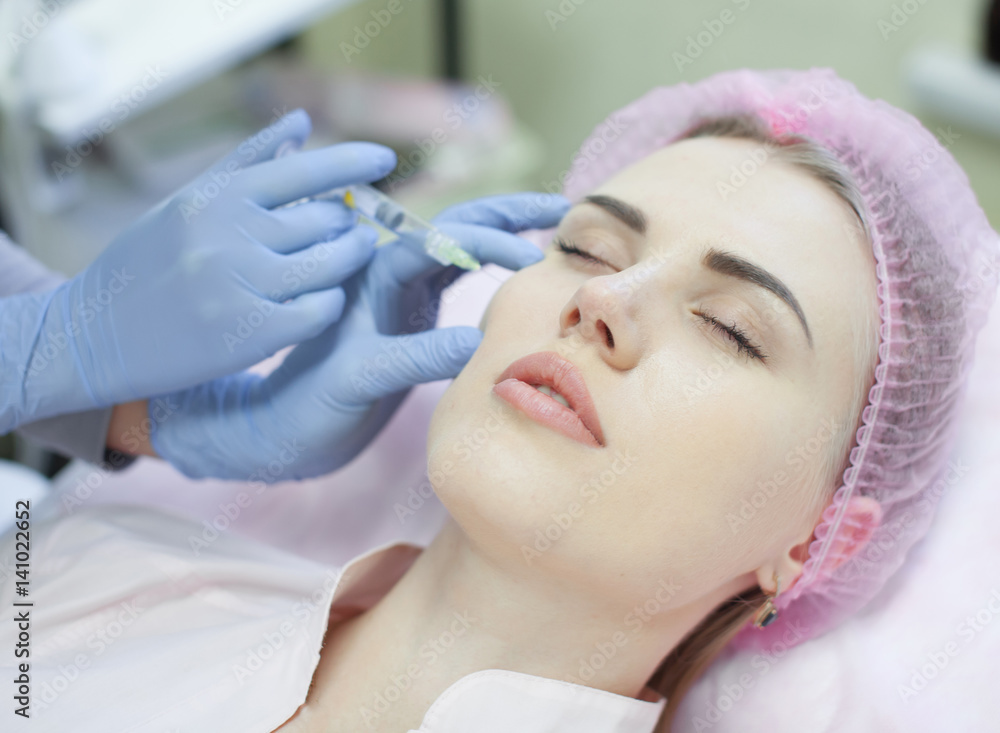 Woman gets injection in her face. Beauty woman giving injections. Young woman gets beauty facial injections in the cosmetology salon. Face aging injection. Aesthetic Medicine, Cosmetology Woman gets injection in her face. Beauty woman giving injections. Young woman gets beauty facial injections in the cosmetology salon. Face aging injection. Aesthetic Medicine, Cosmetology