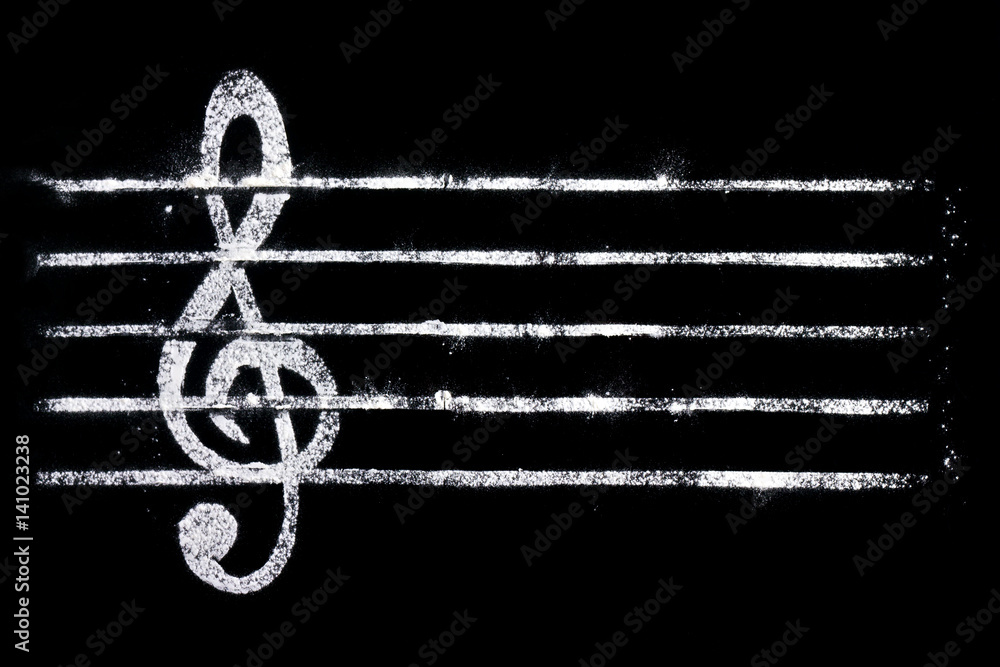 Treble clef from flour on a black background for filling with cooking