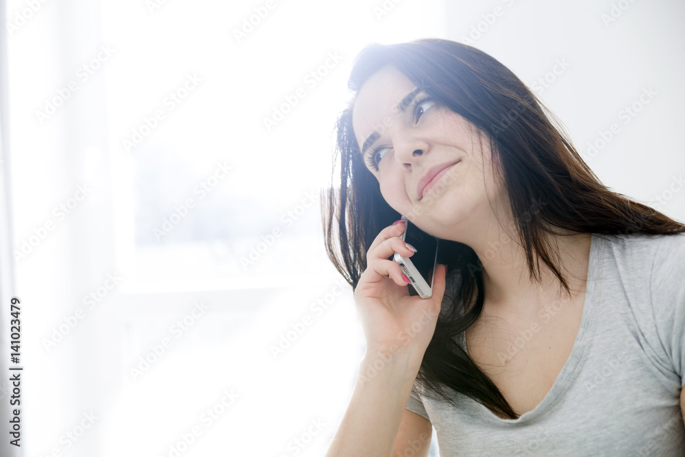 Young woman talking on phone while sitting at home Young woman talking on phone while sitting at home
