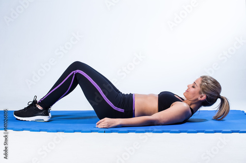 Beautiful female fitness model ready to start training in a studio with edgy lighting