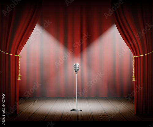 Microphone stands on stage with a red curtain.