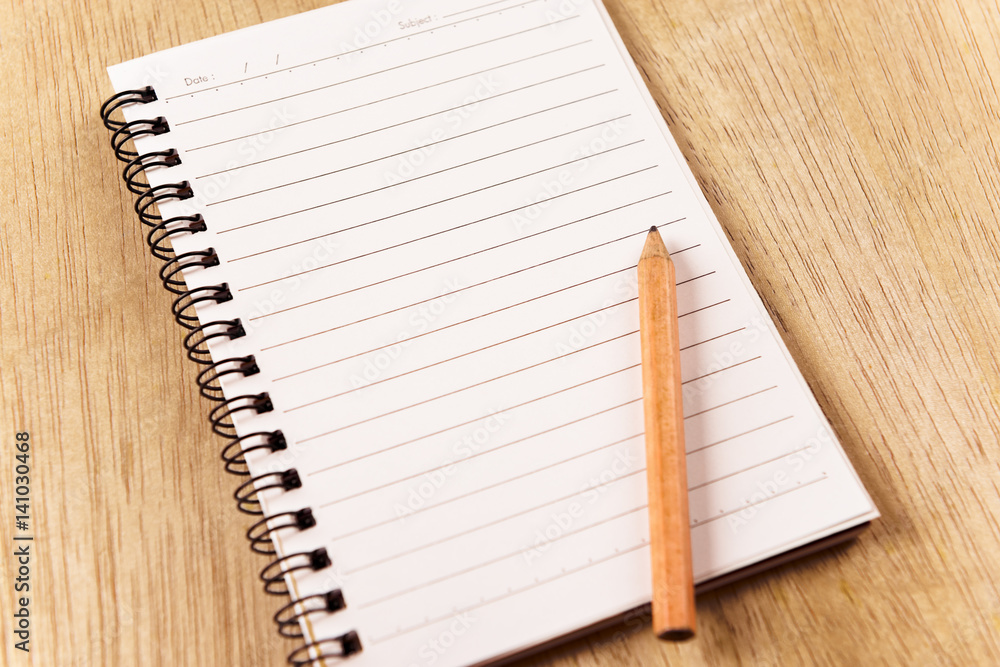 Blank spiral notebook with line paper on wood table Blank spiral notebook with line paper on wood table