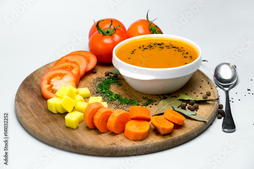 Tomato soup with vegetables In a white plate with an iron spoon