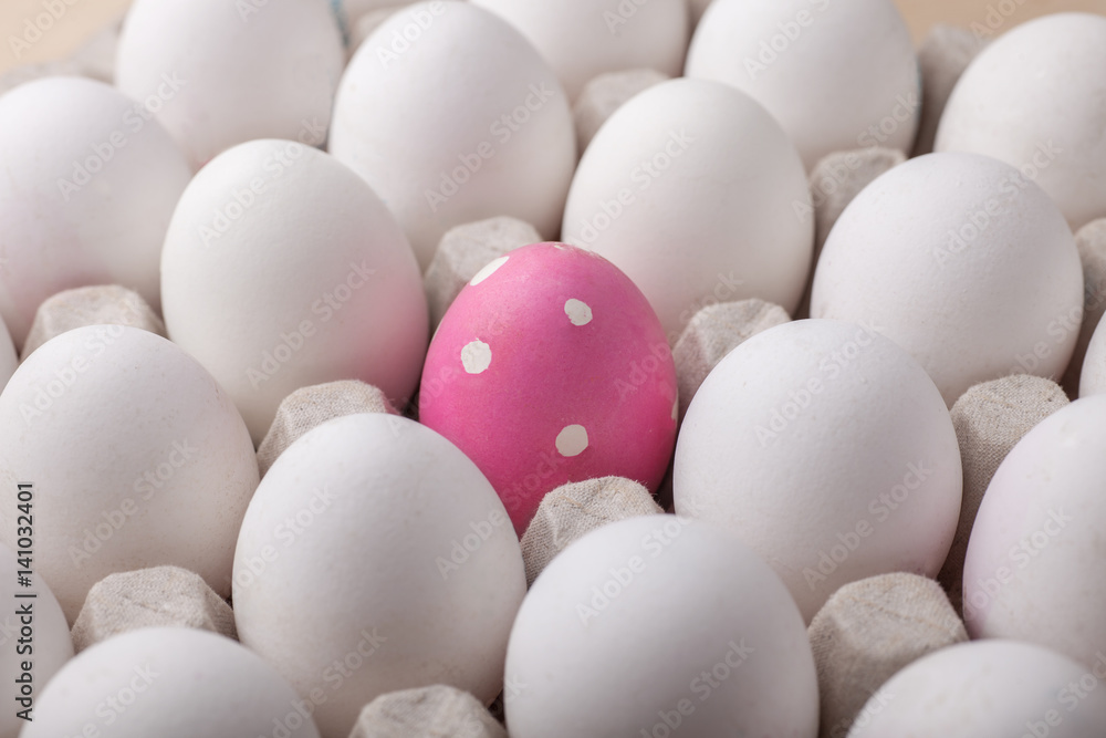easter painted egg among ordinary white eggs in packaging easter painted egg among ordinary white eggs in packaging