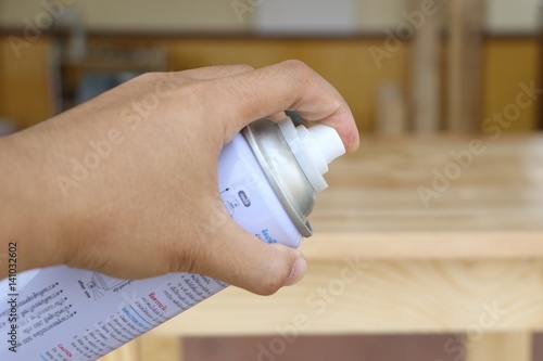 Close up carpenter in his paint room spraying a piece of wood to be used in his workshop later.wood paint.