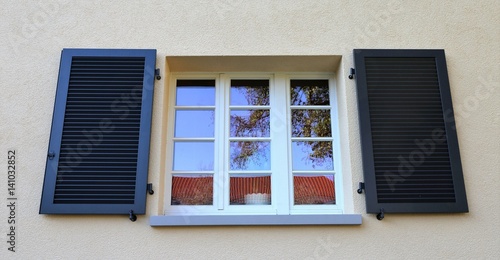 Fenster mit Klappladen aus Holz, Außenaufnahme