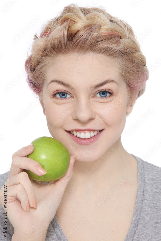 Young beautiful happy smiling young blond girl with green apple over white Young beautiful happy smiling young blond girl with green apple over white