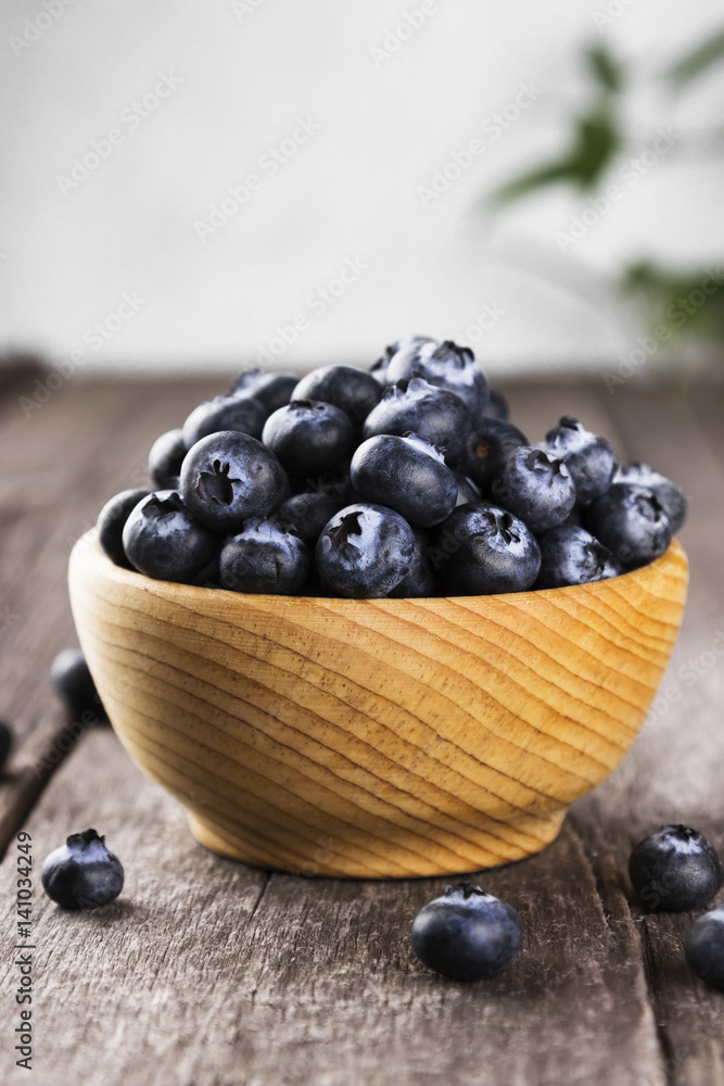 Blueberry in wooden bowl on a dark wooden background Blueberry in wooden bowl on a dark wooden background