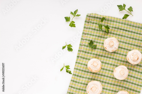 Fresh champignon and parsley on white background. Flat lay.